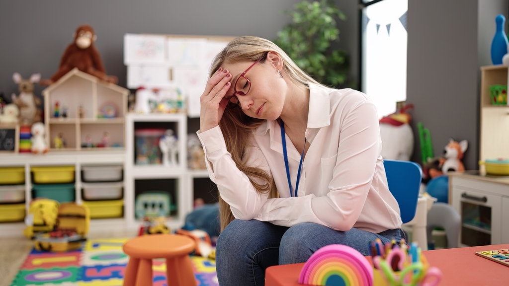 Junge Erzieherin mit entspanntem Ausdruck im Kindergarten